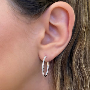 Female model wearing Diamond interior & exterior hoop earrings - 14K gold weighing 4.32 grams  - 58 round diamonds totaling 0.92 carats