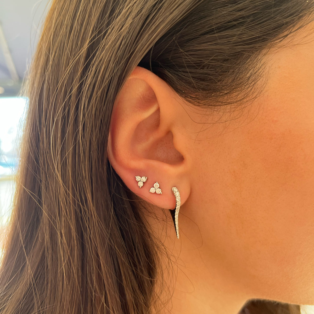 Female Model Wearing Diamond Spike Huggie Earrings - 14K gold weighing 2.55 grams  - 32 round diamonds weighing 0.50 carats