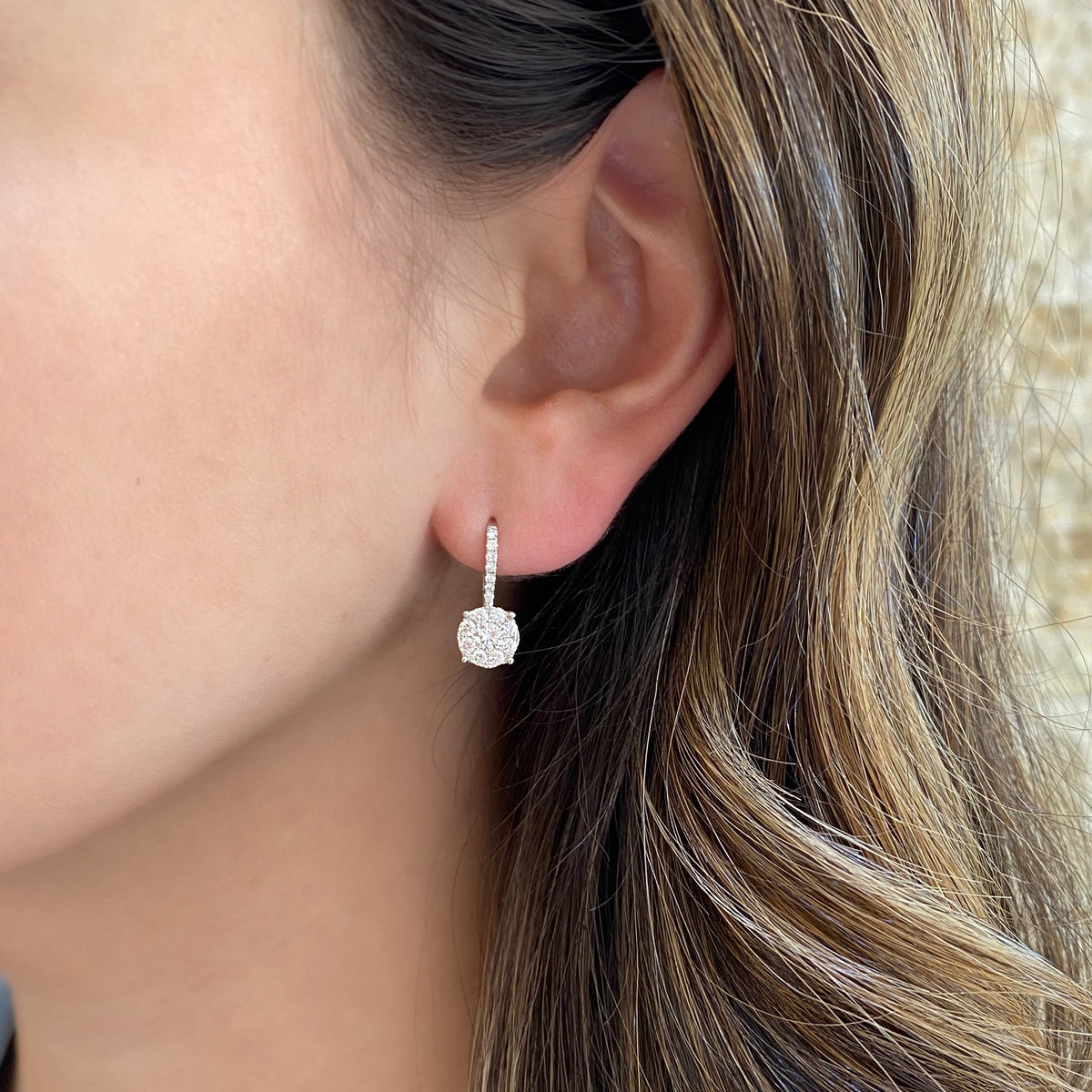 Female Model Wearing Diamond Round Halo Lever-Back Earrings  -18K gold weighing 2.52 grams  -2 round diamonds totaling 0.34 carats  -30 round diamonds totaling 0.55 carats