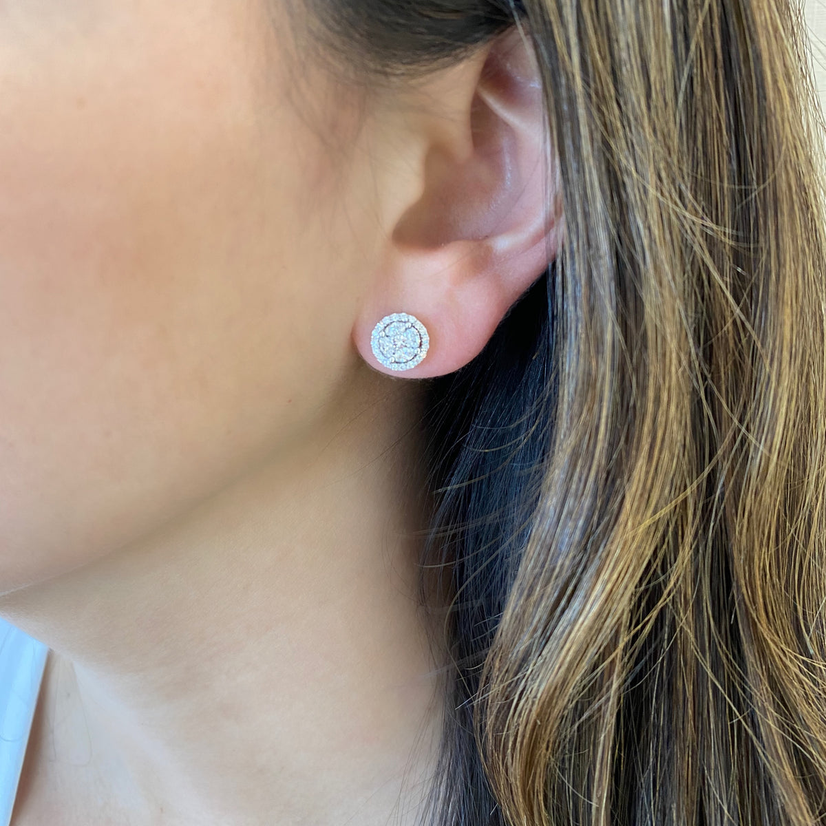 Female model wearing marquise & princess illusion diamond halo studs -18k gold 3.23 grams  -8 marquise prong-set diamonds .48 carats  -2 princess cut diamonds .24 carats  -38 round pave-set diamonds .21 carats.