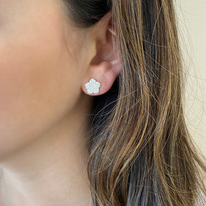 female model wearing diamond flower stud earrings 18k Gold weighing 2.19 grams 62 round pave set diamonds weighing .83 carats