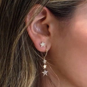 Side shot of woman wearing Diamond Triple Star Dangle Earrings -14K gold weighing 2.44 grams -128 round pave-set diamonds totaling 0.28 carats