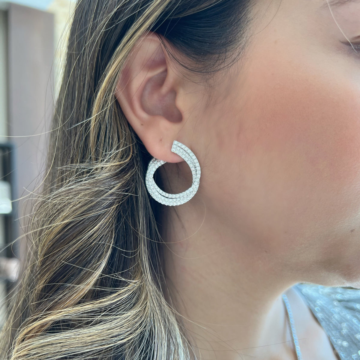 Female Model Wearing Diamond Front-Facing Twist Hoop Earrings -14K gold weighing 9.71 grams -214 round pave-set diamonds totaling 3.55 carats