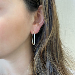 Female Model Wearing Diamond Interior and Exterior Medium Hoop Earrings - 14K gold weighing 8.4 grams  - 66 round diamonds totaling 1.82 carats