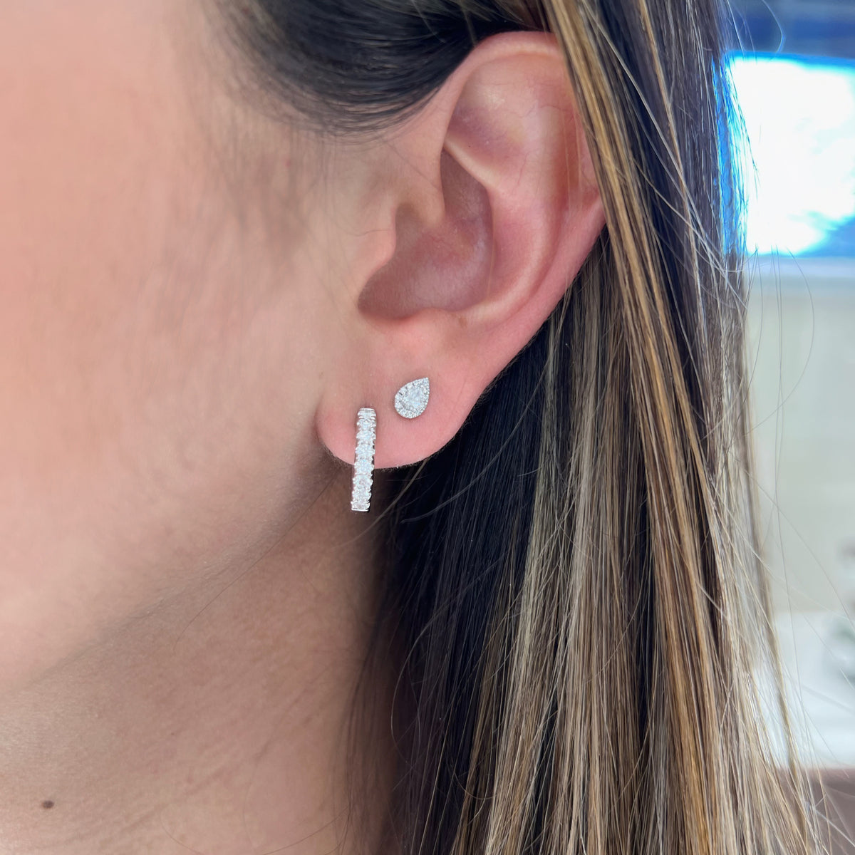 Female model wearing Thick Diamond Huggie Earrings 14k gold, 4.4 grams  16 round shared prong-set brilliant diamonds weighing .48 carats.