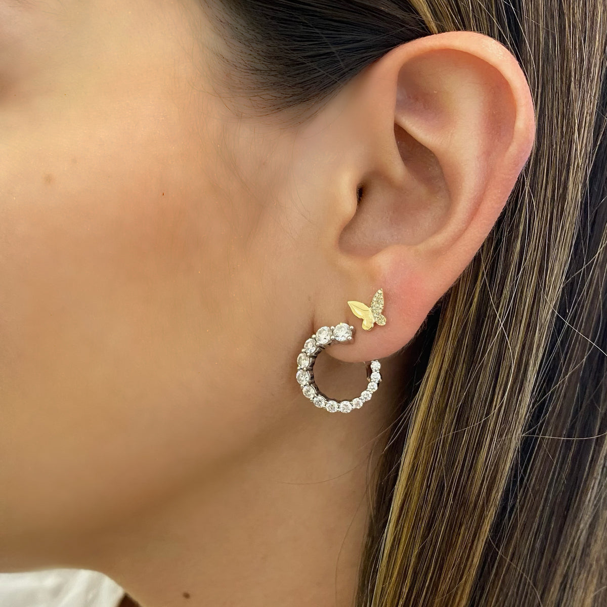 Female model wearing Half Diamond Butterfly Stud Earrings - 14K gold weighing 1.30 grams - 38 round diamonds totaling 0.09 carats