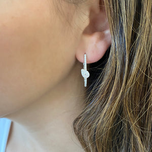 Female model wearing Diamond Oval Hoop Earrings with diamond teardrops -14K gold weighing 5.33 grams  -66 round diamonds totaling 0.84 carats