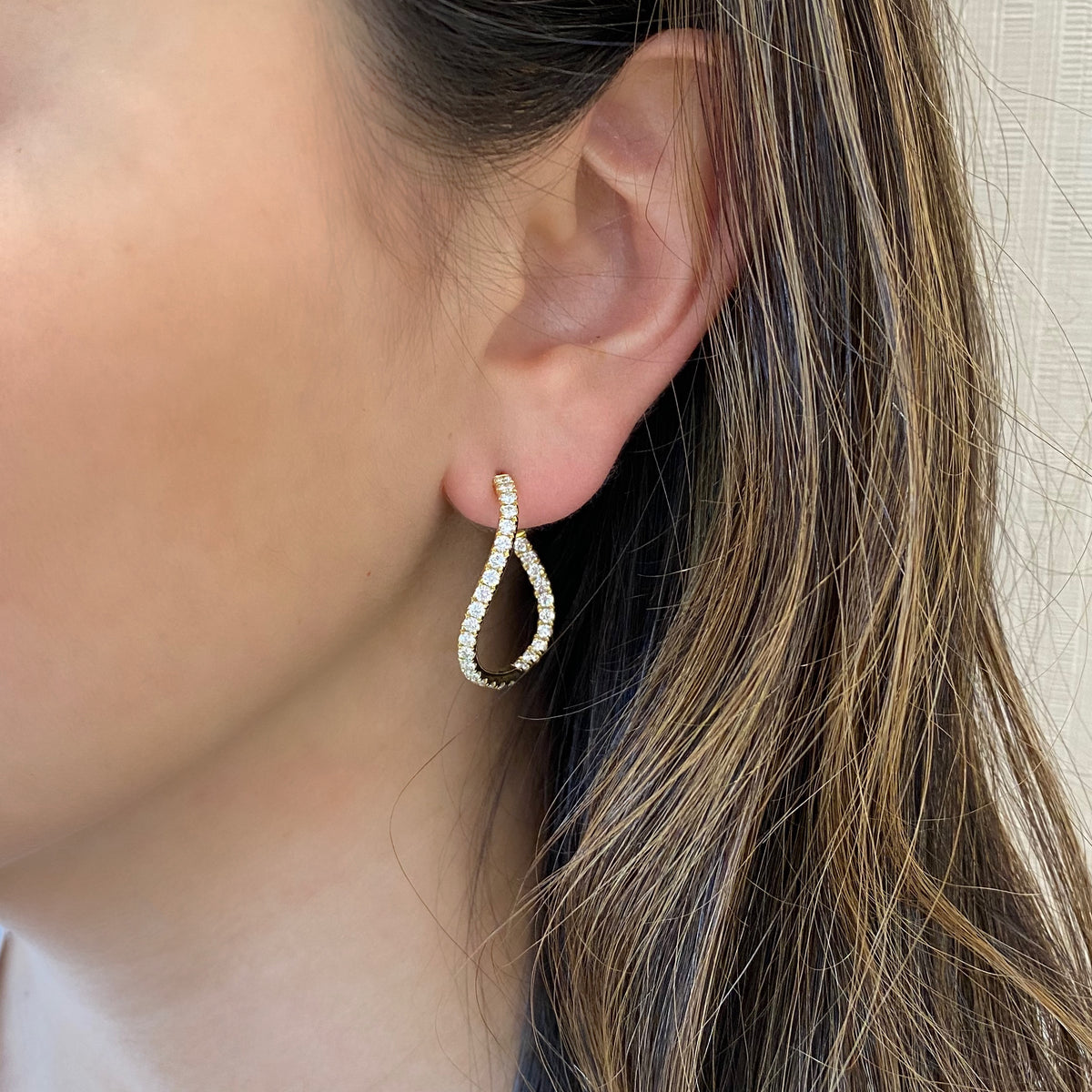 Female Model Wearing Small Diamond Twist Hoop Earrings -18K gold weighing 6.25 grams  -58 round diamonds totaling 1.78 carats