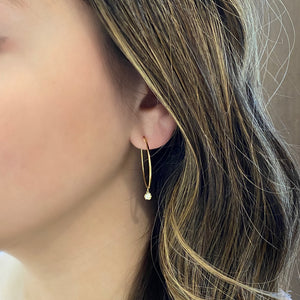 Female Model Wearing Gold Hoop Earrings With Bezel-Set Diamond -14k gold weighing 2.65 grams  -2 round bezel set diamonds weighing .14 carats