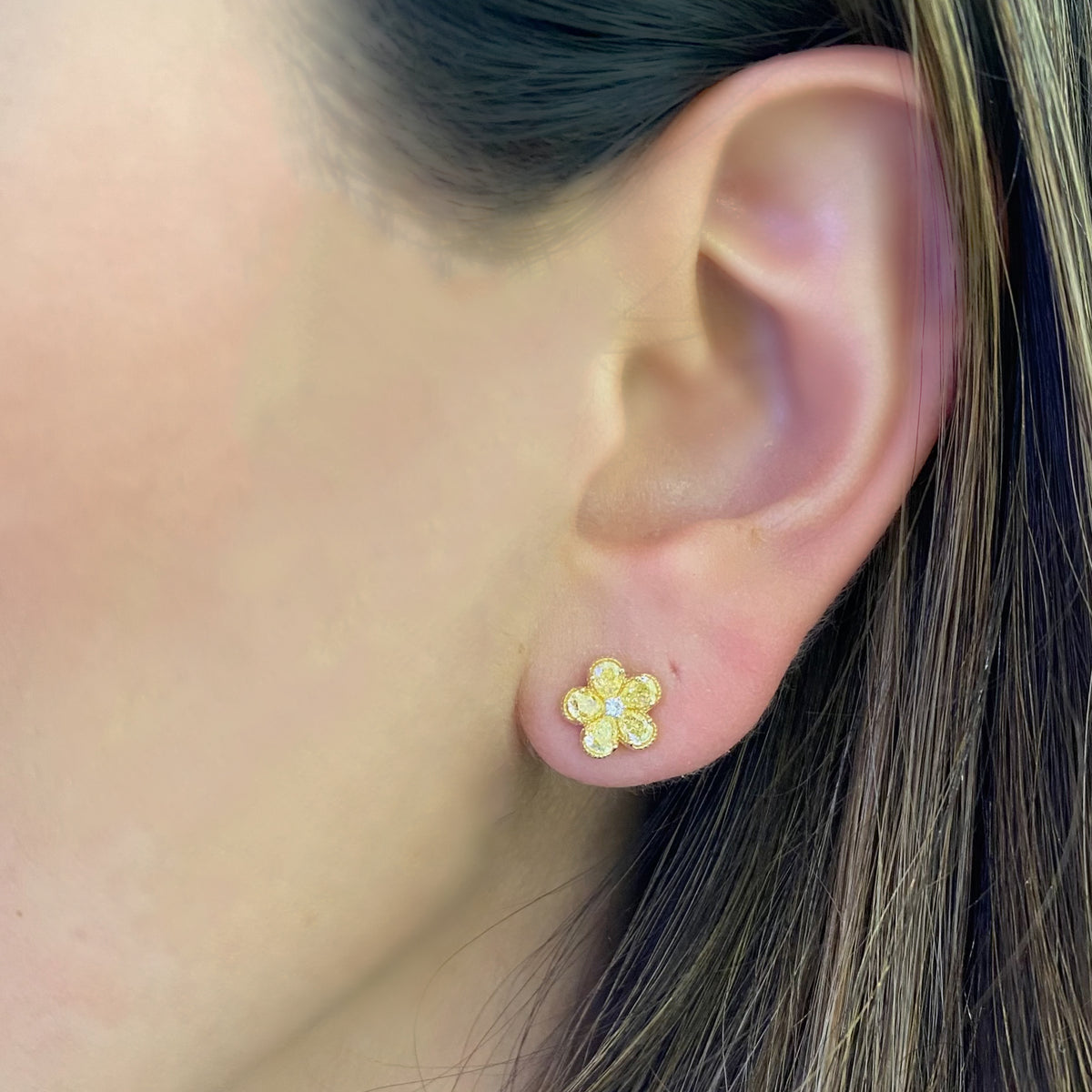 Female Model Wearing Yellow Diamond Flower Stud Earrings - 18K gold weighing 2.46 grams - 2 round diamonds weighing 0.03 carats - 10 yellow pear-shaped diamonds weighing 1.11 carats