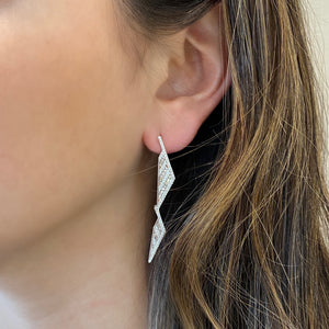 Female Model Wearing  Diamond Triangle Drop Earrings  -18K gold weighing 7.87 grams  -148 round diamonds totaling 0.52 carats  -58 straight baguettes totaling 0.52 carats