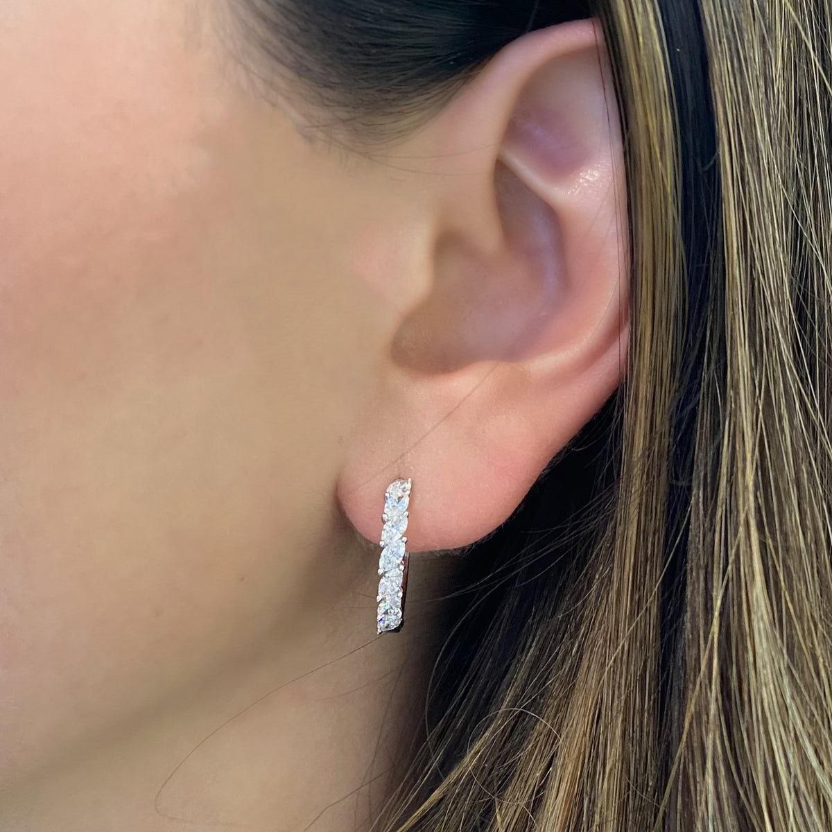 Female model wearing Marquise-Shaped Diamond Huggies - 18K gold weighing 3.82 grams  - 14 marquise-shaped diamonds weighing 1.12 carats