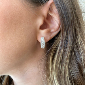 Female model wearing Round Diamond Tapered Huggie Earrings - 18K gold weighing 6.02 grams - 70 round diamonds weighing 1.48 carats