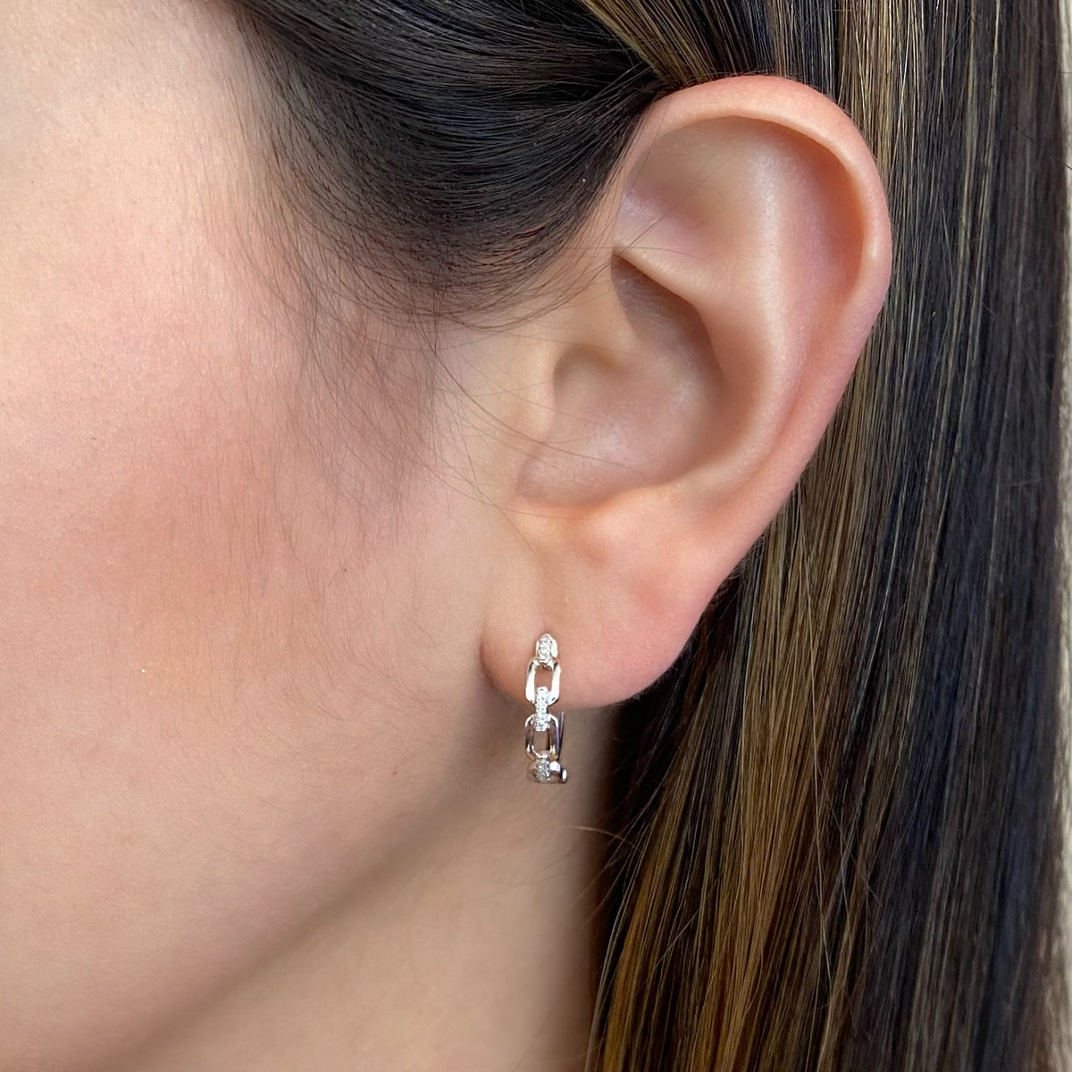 Female Model Wearing Diamond Elongated Chain Link Huggie Earrings - 14K gold weighing 2.43 grams  - 24 round diamonds totaling 0.08 carats