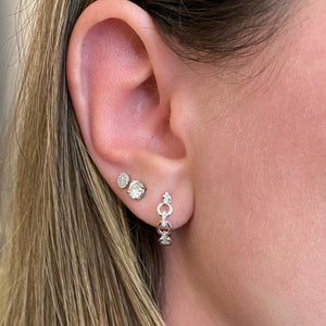 Female model wearing Diamond circular chain link huggie earrings  - 14K gold weighing 2.94 grams  - 24 round diamonds totaling 0.08 carats