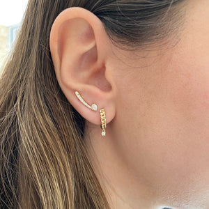 Female model wearing pear-shaped diamond crawler earrings - 14K gold weighing 1.73 grams  - 2 pear-shaped diamonds weighing 0.22 carats  - 24 round diamonds weighing 0.24 carats