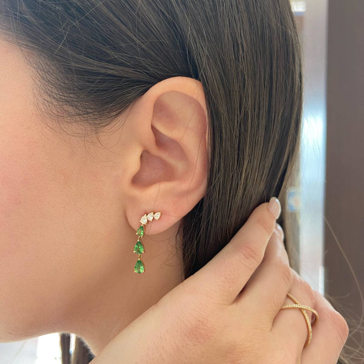 Female model wearing Tsavorite and Diamond Drop Earrings - 14K gold weighing 2.22 grams - 6 pear-shaped tsavorites weighing 1.36 carats - 6 pear-shaped diamonds weighing 0.64 carats