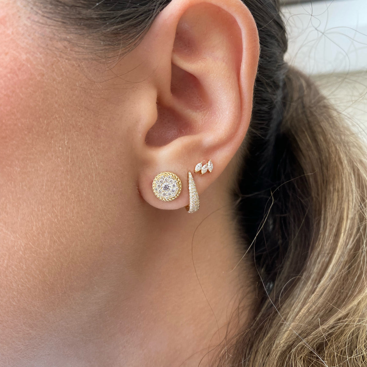 Female model wearing Pave Diamond Dome Huggie Earrings - 14K yellow gold weighing 1.47 grams  - 96 round diamonds weighing 0.29 carats