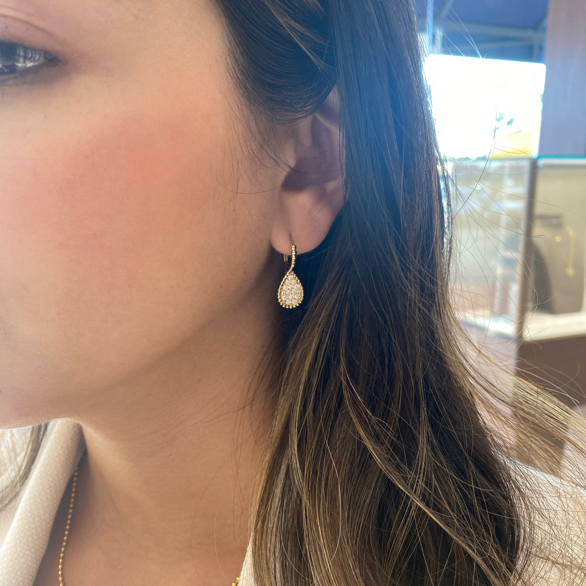 Female Model Wearing Diamond Pear Drop Lever-Back Earrings - 14K gold weighing 2.93 grams  - 30 round diamonds weighing 0.65 carats