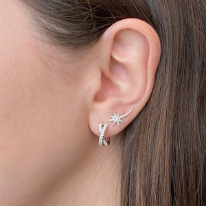Female model wearing Diamond crossover huggie earrings - 14K gold  - 32 round diamonds totaling 0.40 carats