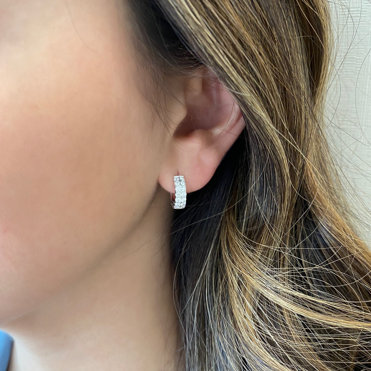 Female model wearing Diamond double row huggie earrings - 18K gold weighing 2.80 grams  - 28 round diamonds totaling 0.70 carats