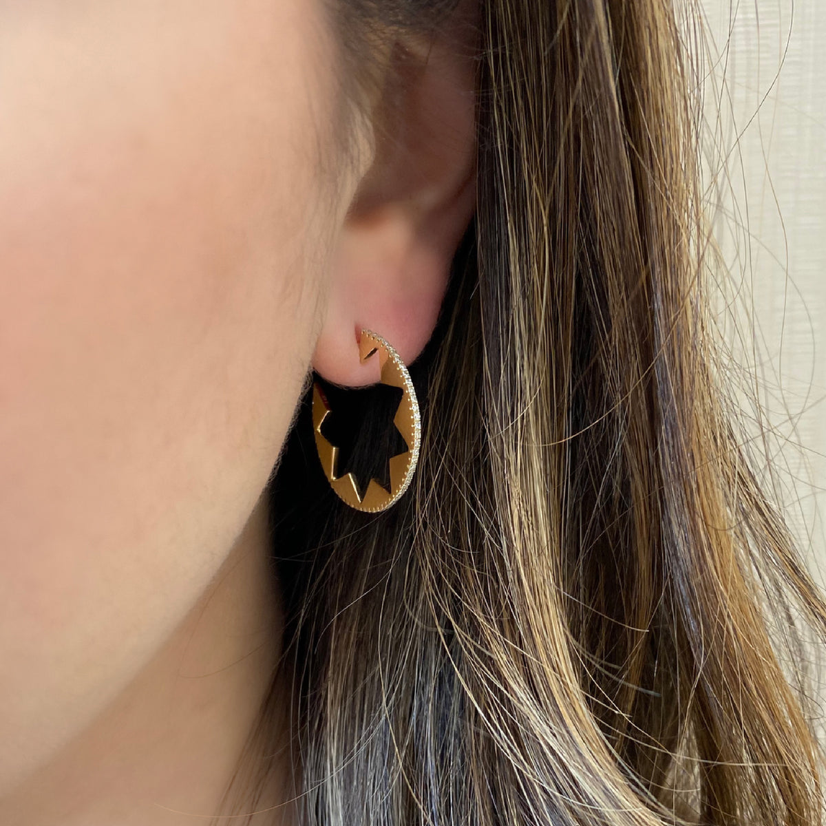 Female model wearing Diamond star cut-out cocktail earrings -14k gold weighing 4.75 grams  -110 round diamond weighing .44 carats