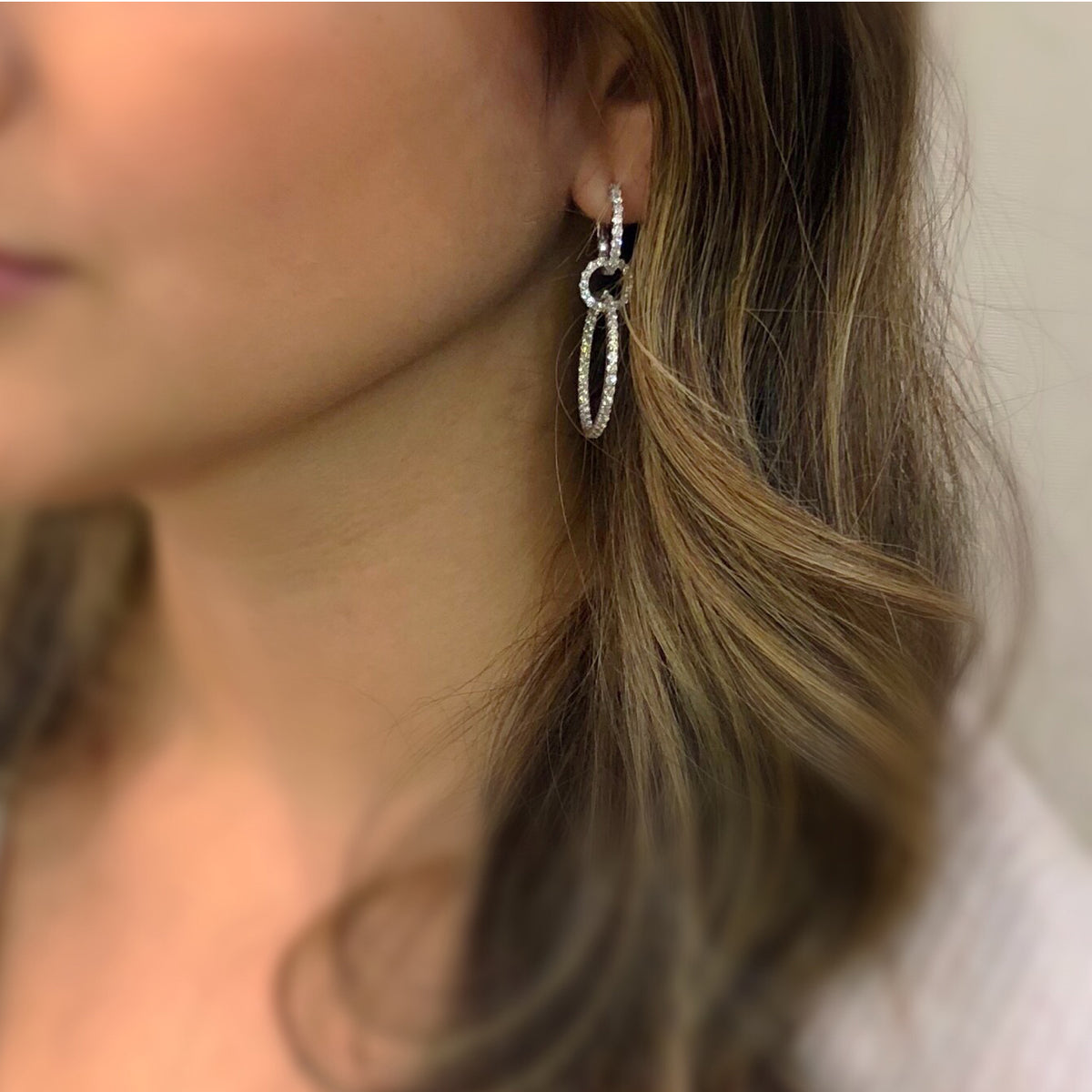 Female Model Wearing Diamond Dangle Cocktail Earrings  -14K gold weighing 5.56 grams  -134 round diamonds totaling 2.65 carats