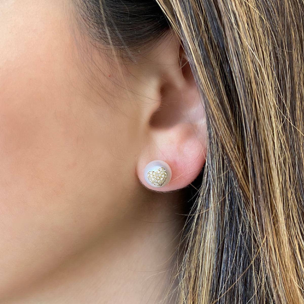 Female model wearing Pearl & Diamond Heart Earrings - 14K gold weighing 1.38 grams - 52 round diamonds totaling 0.17 carats