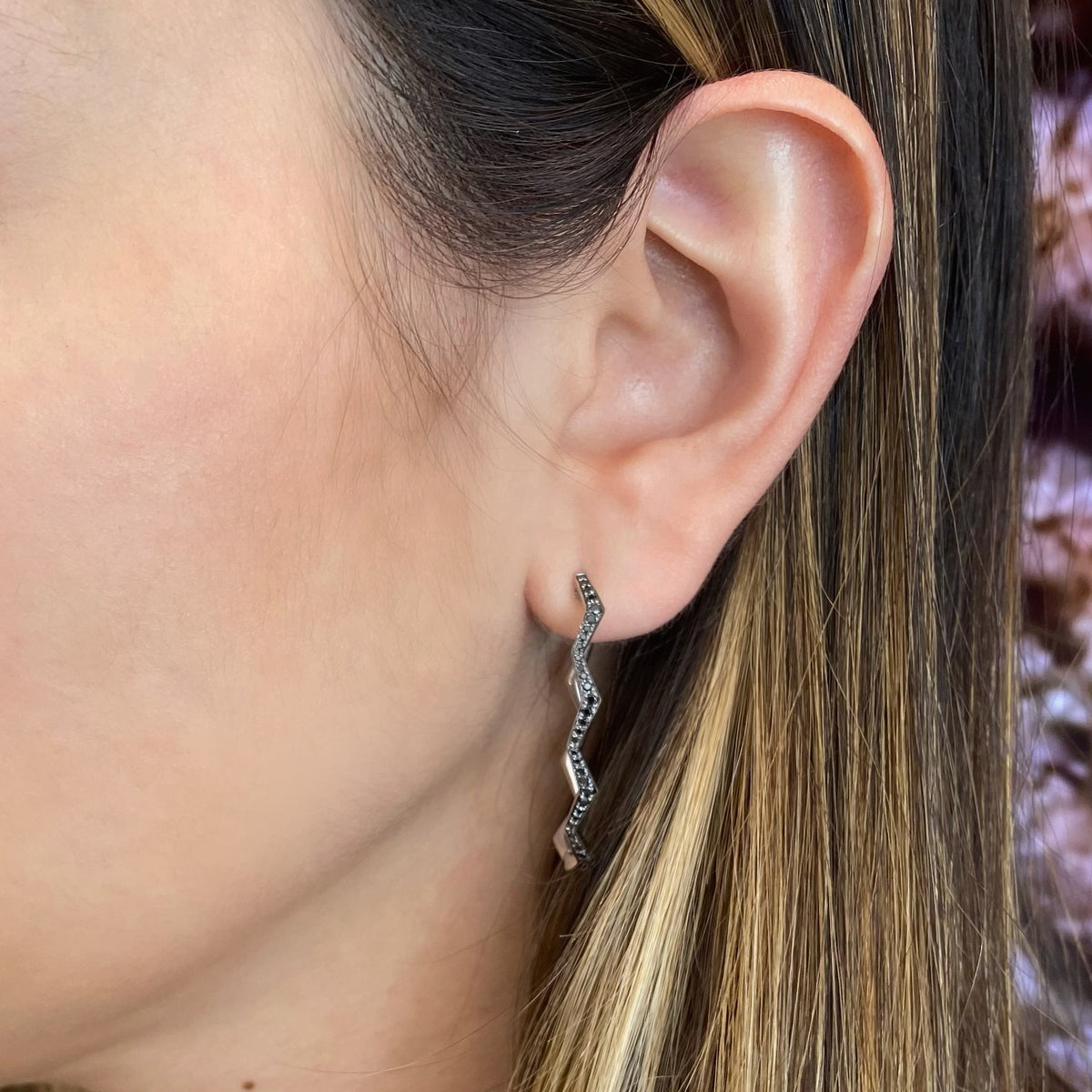 Female model wearing Black diamond zig-zag hoop earrings - 14K gold  - 0.35 cts round diamonds