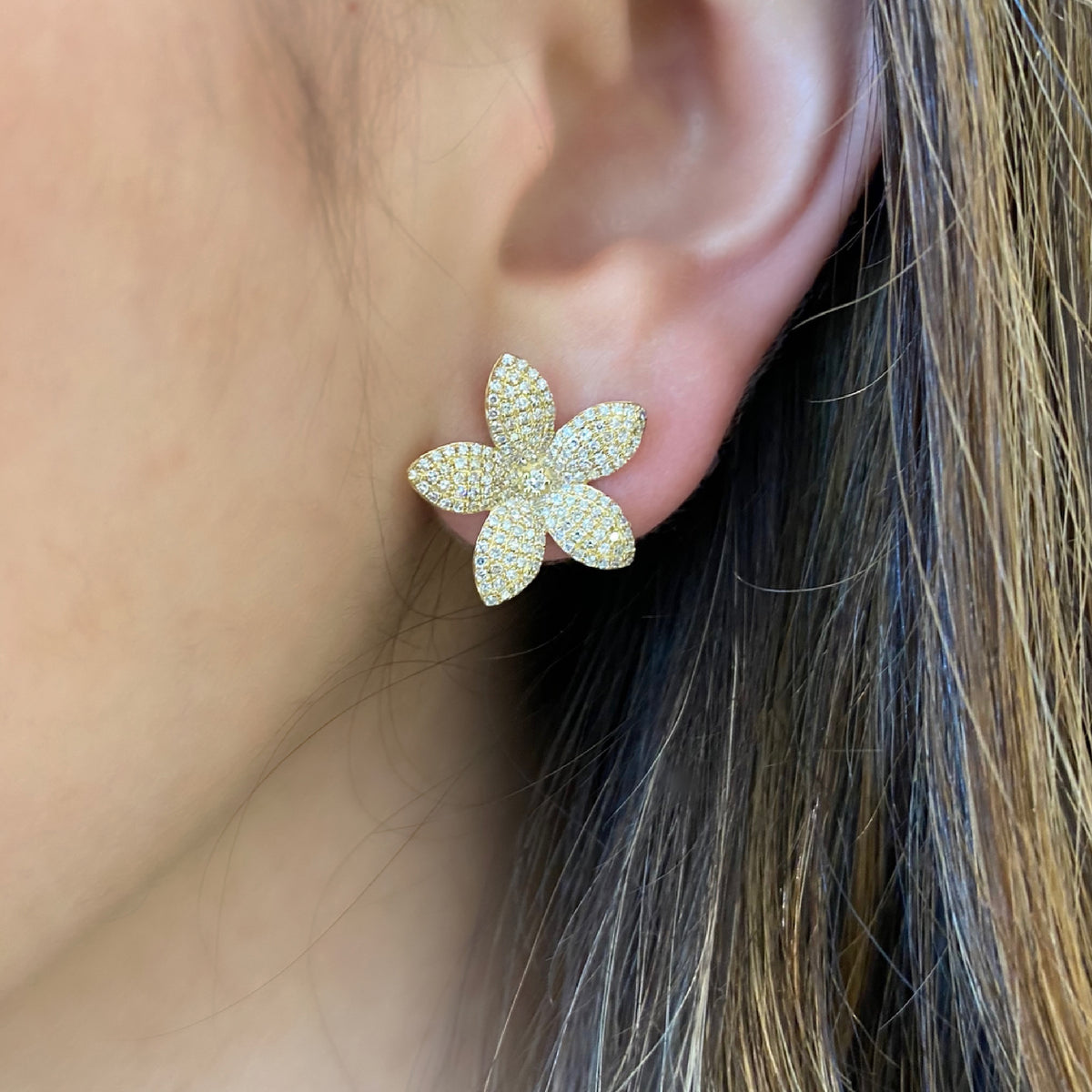 female model wearing pave diamond flower stud earrings -14K gold weighing 3.32 grams -342 round diamonds totaling 0.90 carats