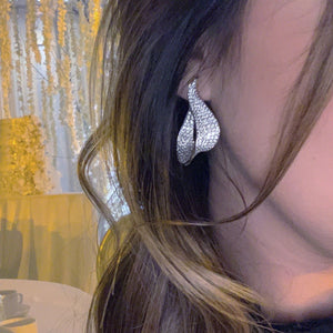 Female Model Wearing Diamond Swoop Earrings  - 14K gold weighing 11.80 grams.  - 362 round diamonds totaling 4.72 carats. 