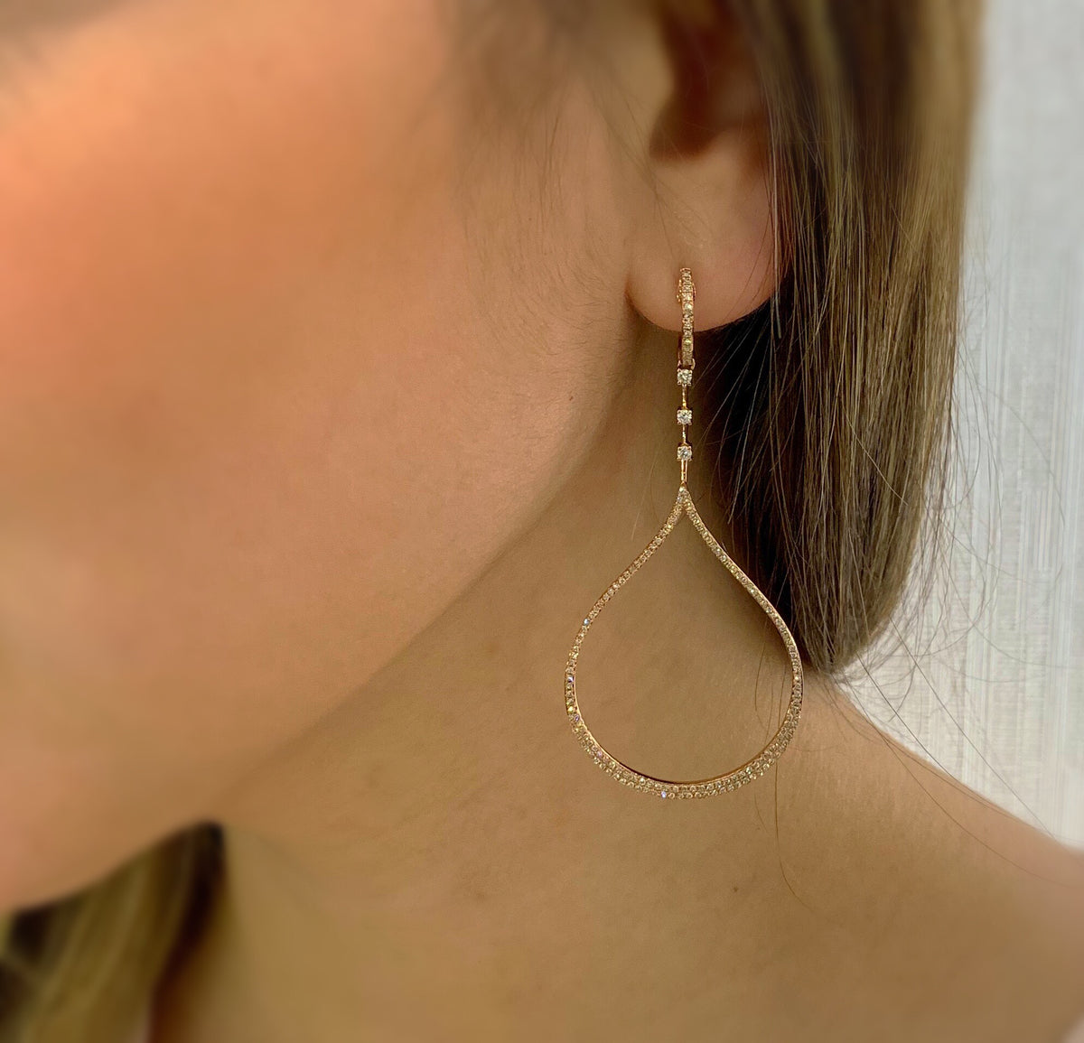 Female Model Wearing Diamond Open Teardrop Dangle Earrings  -14K gold weighing 6.37 grams  -306 round diamonds totaling 0.78 carats  -6 prong-set diamonds totaling 0.16 carats