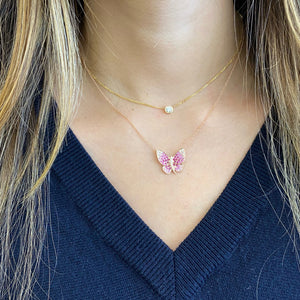 Female model wearing Diamond & Sapphire Butterfly Pendant Necklace -14k gold weighing 3.93 grams -white sapphire & pink sapphire weighing .74 carats -18 round diamonds weighing .04 carats