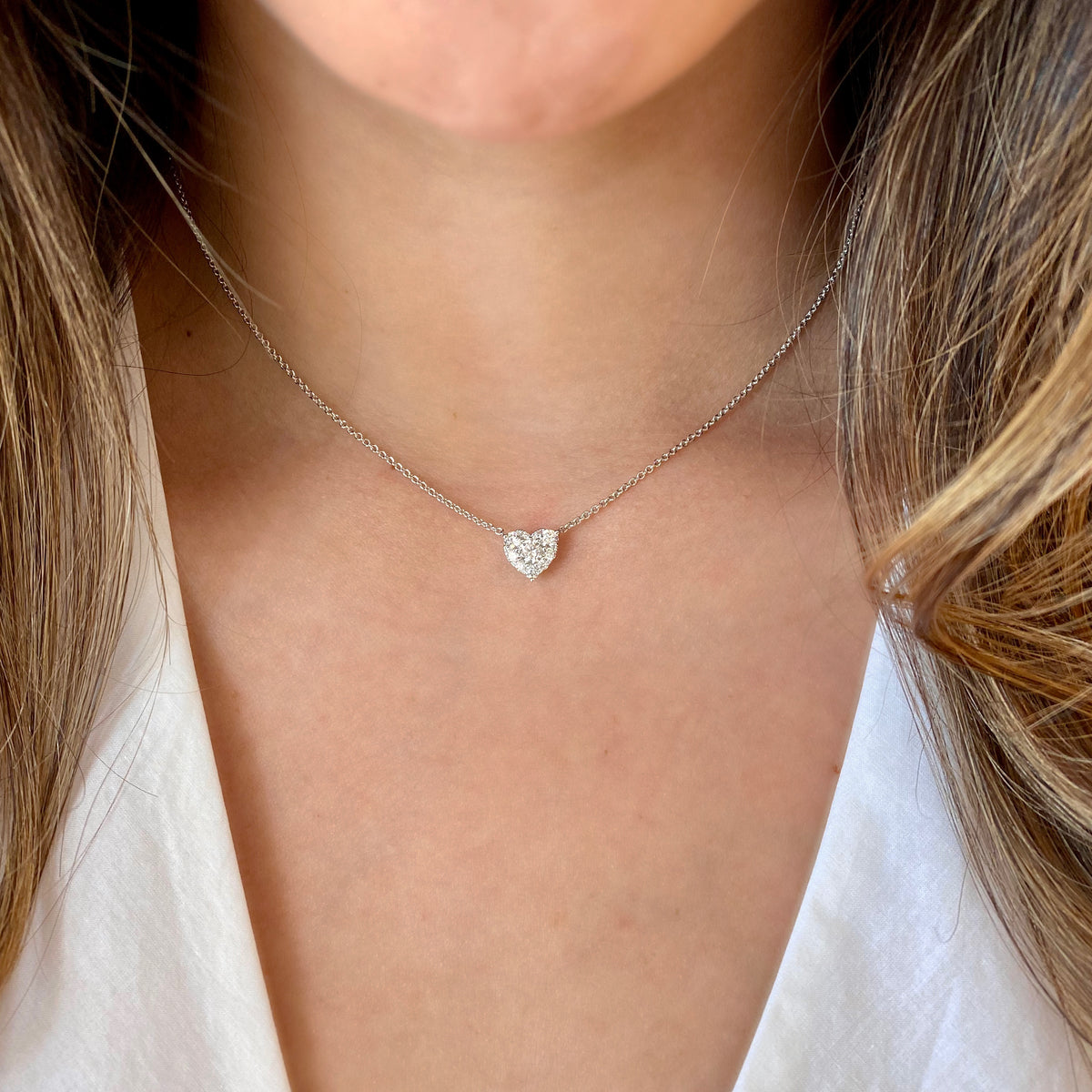 Female Model Wearing Diamond Cluster Heart Pendant Necklace  -14K gold weighing 2.77 grams  -10 round diamonds totaling 0.60 carats