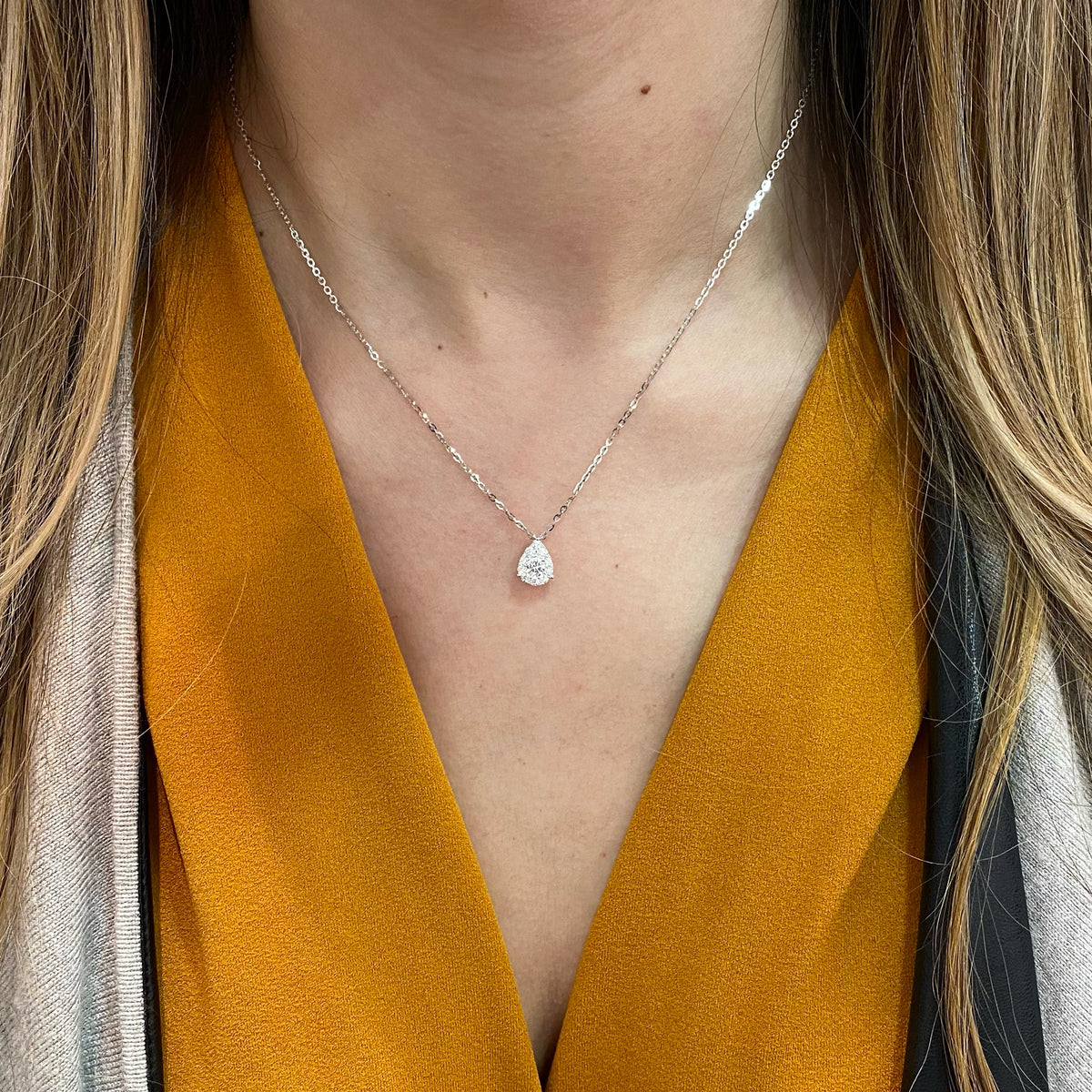Female Model Wearing Diamond Teardrop Pendant  - 18K gold weighing 2.57 grams  - 0.24 ct round diamond  - 10 round diamonds totaling 0.28 carats
