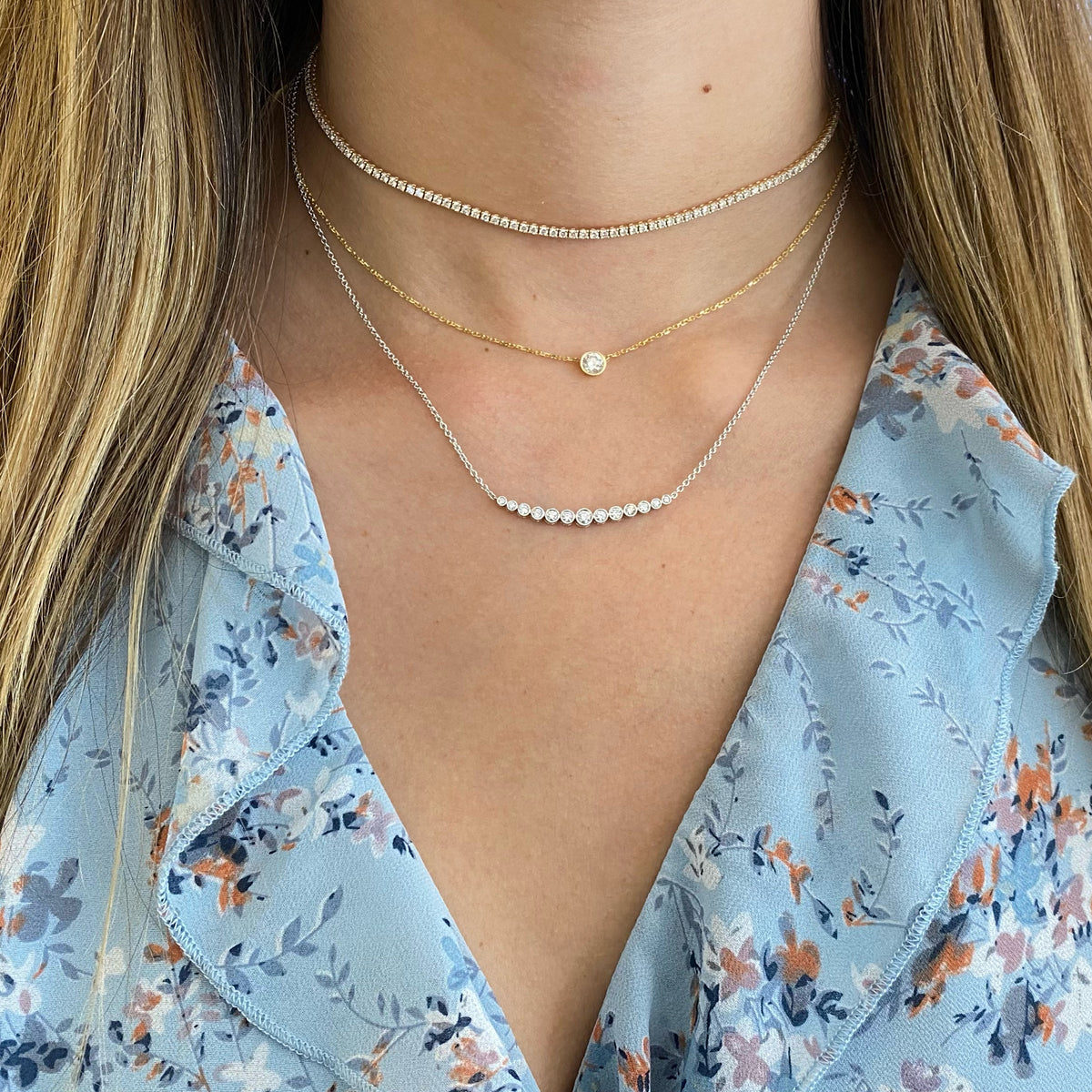 Female model wearing Bezel-Set Diamond Arch Pendant -18K gold weighing 3.95 grams -13 round diamonds totaling 0.37 carats