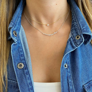 Female Model Wearing Mixed Cut Diamond Bar Necklace  - 18K gold weighing 3.48 grams  - 2 marquise-shaped diamonds totaling 0.18 carats  - 11 round diamonds totaling 0.19 carats  - 4 tapered baguettes totaling 0.17 carats