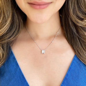 Female Model Wearing Diamond Large Rectangle Pendant with Bezel-Set Diamond Stations  - 18K gold weighing 5.55 grams  - 12 round diamonds totaling 0.34 carats  - 6 straight baguettes totaling 0.93 carats