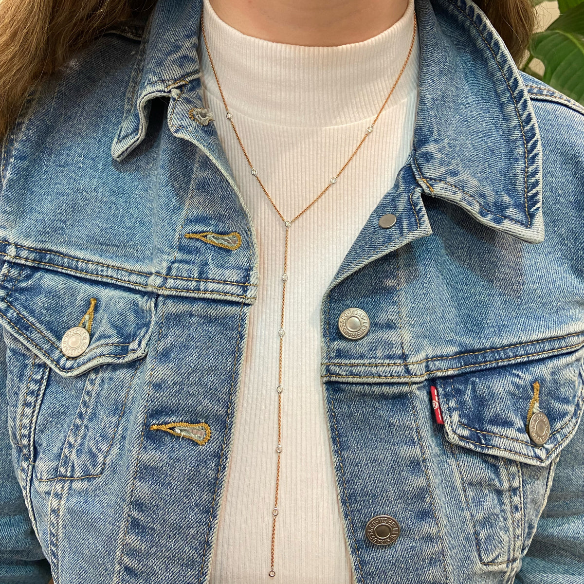 Female Model Wearing Lariat Diamond Station Necklace  14k gold, 4.75 grams, 11 round bezel-set diamonds weighing .56 carats.