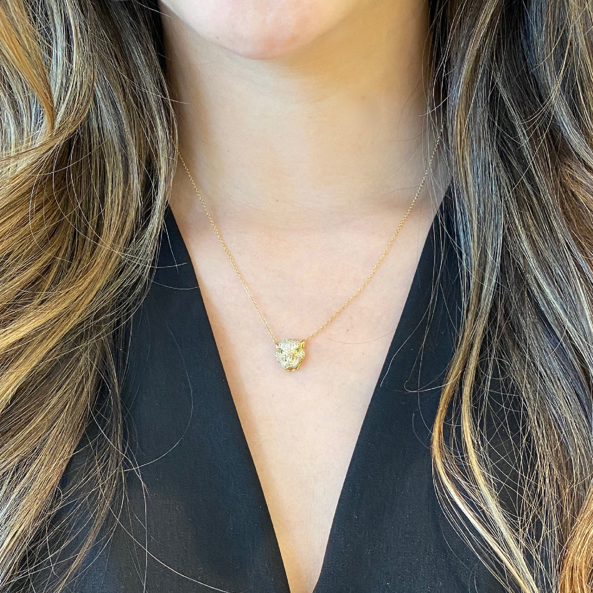 Female model wearing Diamond & Emerald Tiger Pendant Necklace -14K gold weighing 2.72 grams -138 round pave set diamonds weighing 0.58 carats -2 emeralds weighing .02 ca