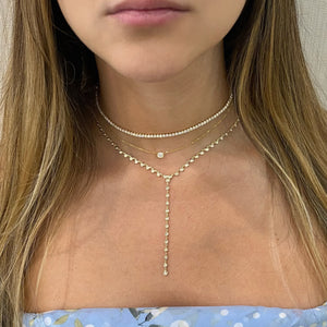 Female Model Wearing Bezel-Set Diamond Lariat Necklace  -14K gold weighing 5.69 grams  -43 round bezel-set diamonds weighing 0.52 carats