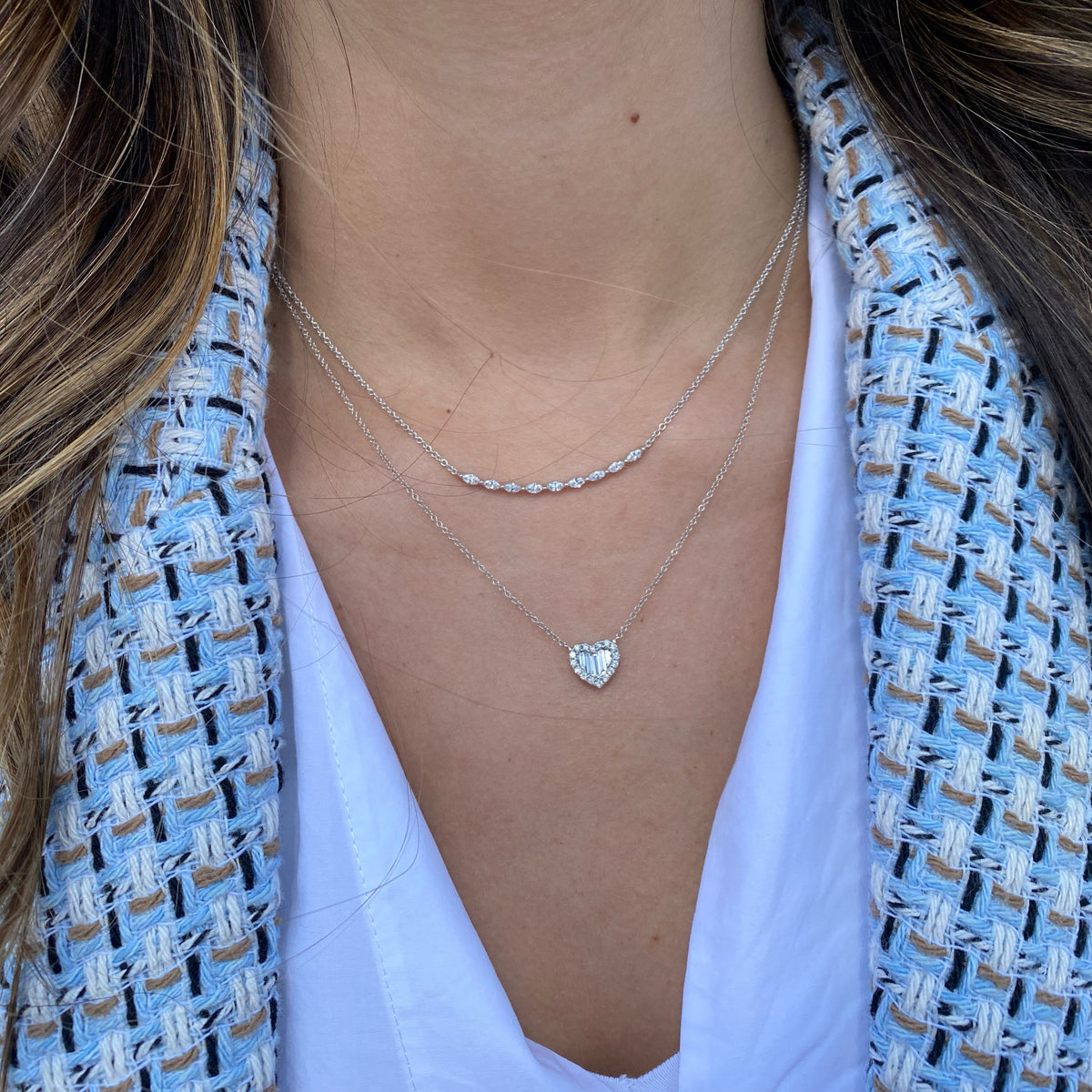 Female model wearing Round and Baguette Diamond Heart Pendant Necklace - 14K gold weighing 2.39 grams - 16 round diamonds weighing 0.19 carats - 5 slim baguettes weighing 0.19 carats