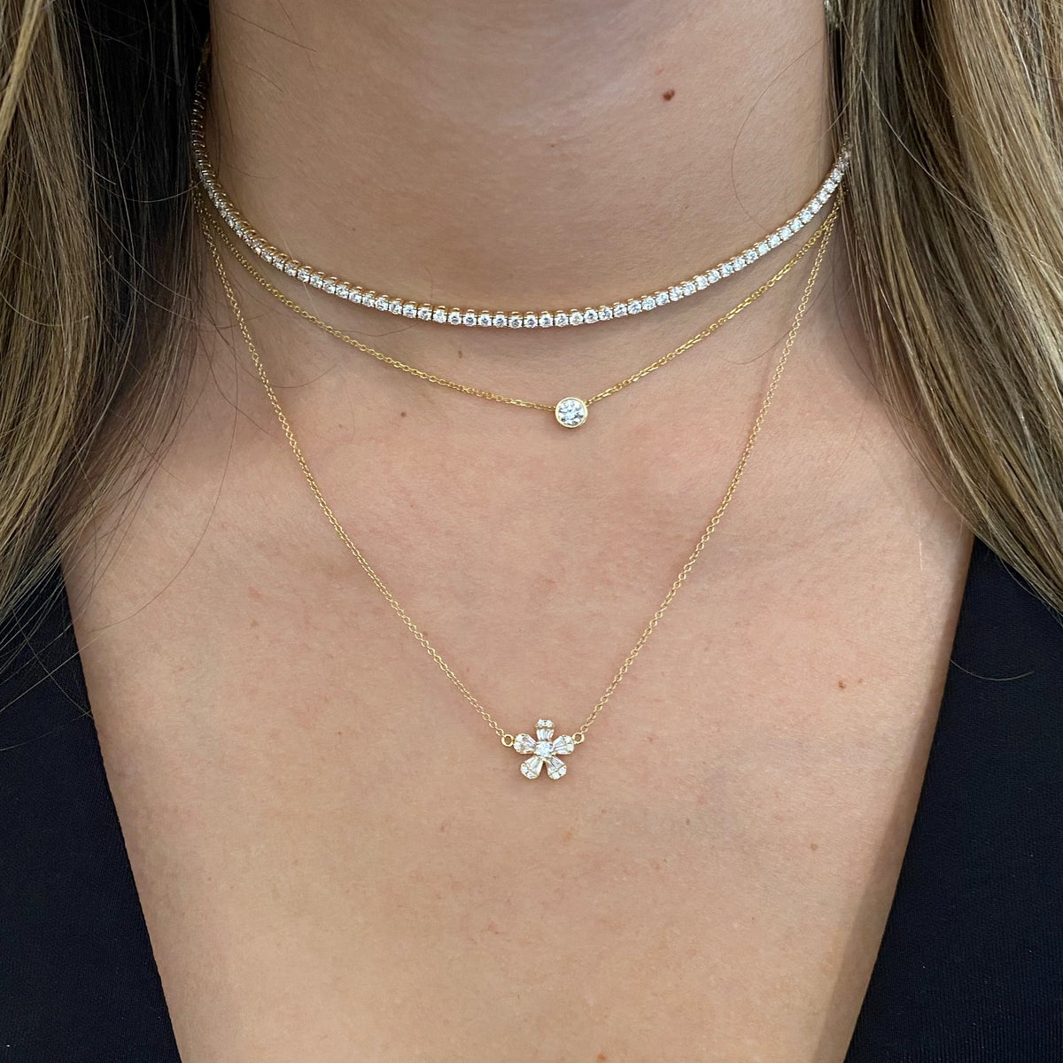 Female Model Wearing Round & Baguette Diamond Flower Necklace  - 14K gold weighing 2.38 grams  - 10 slim baguettes totaling 0.23 carats  - 11 round diamonds totaling 0.16 carats