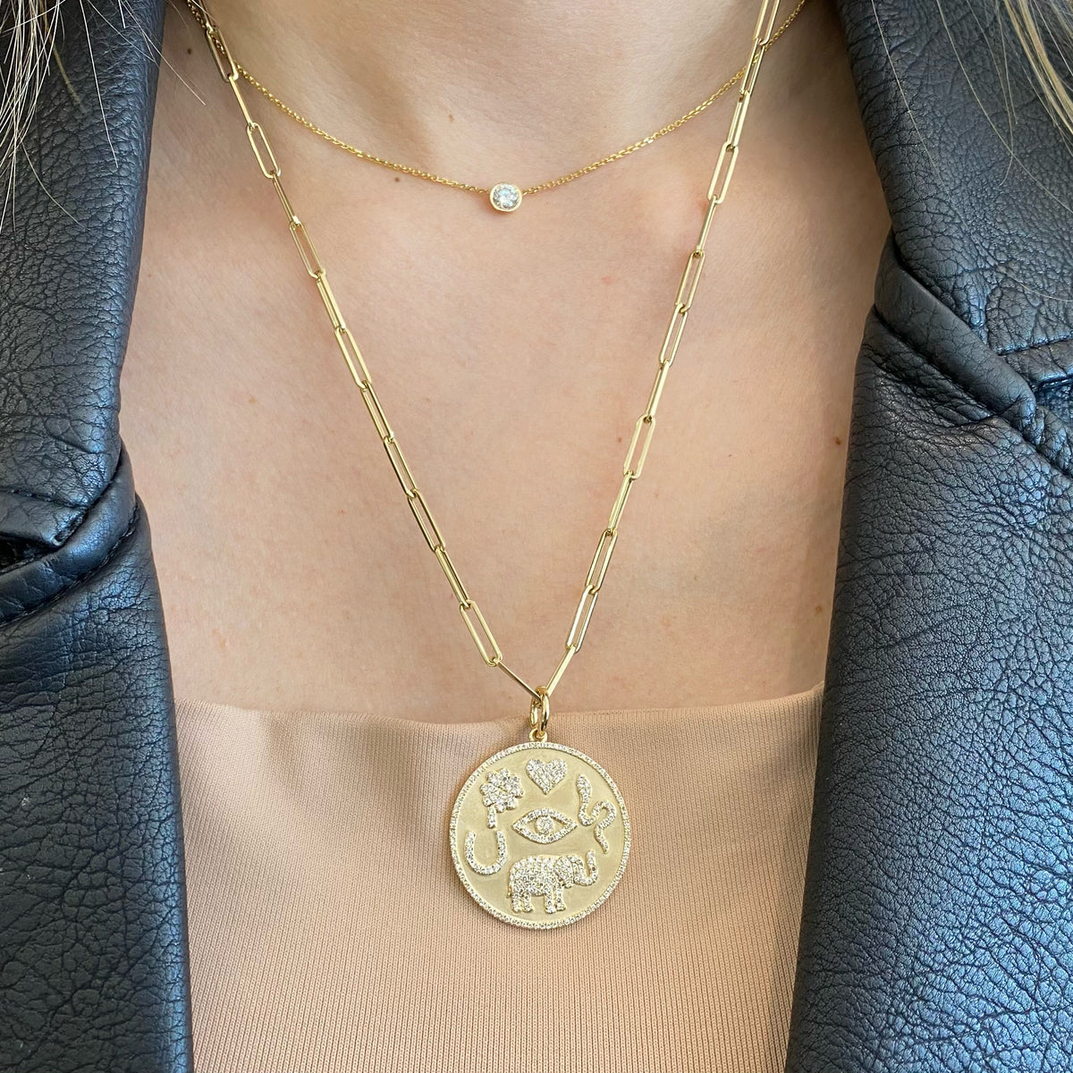 Female model wearing Diamond Good Luck Charm Necklace - 14K gold weighing 4.24 grams - 277 round diamonds totaling 0.64 carats