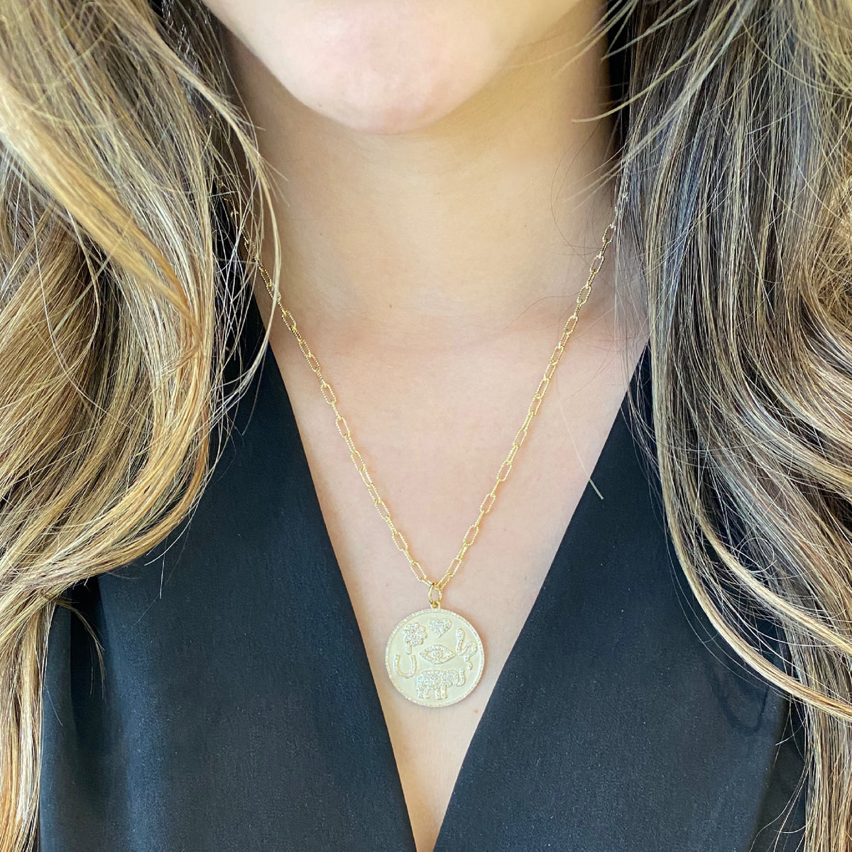 Female model wearing Diamond Good Luck Charm Necklace - 14K gold weighing 4.24 grams - 277 round diamonds totaling 0.64 carats