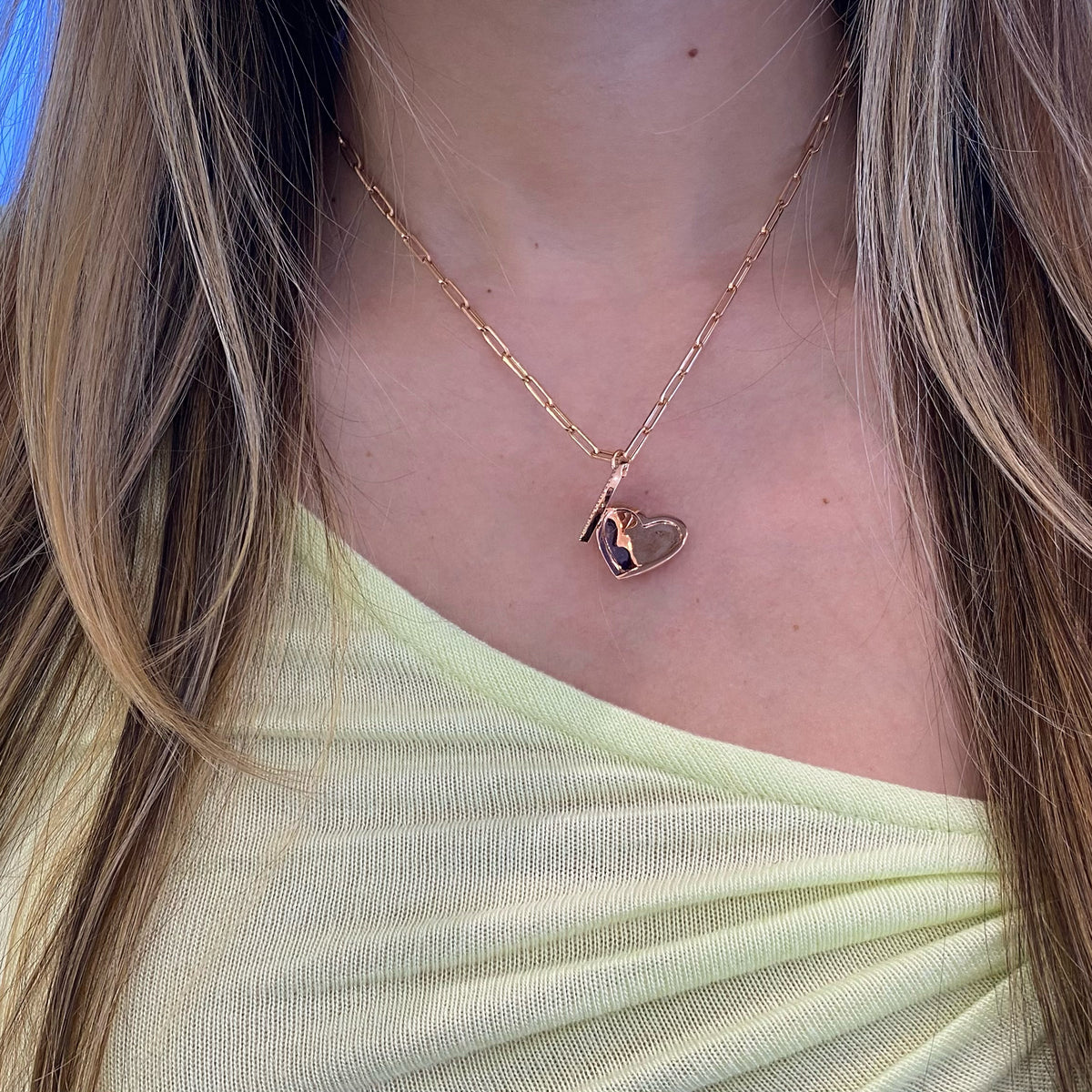 Female model wearing Lapis & Diamond Heart Locket - 14K gold weighing 3.89 grams - 50 round diamonds totaling 0.16 carats - 3.71 ct lapis