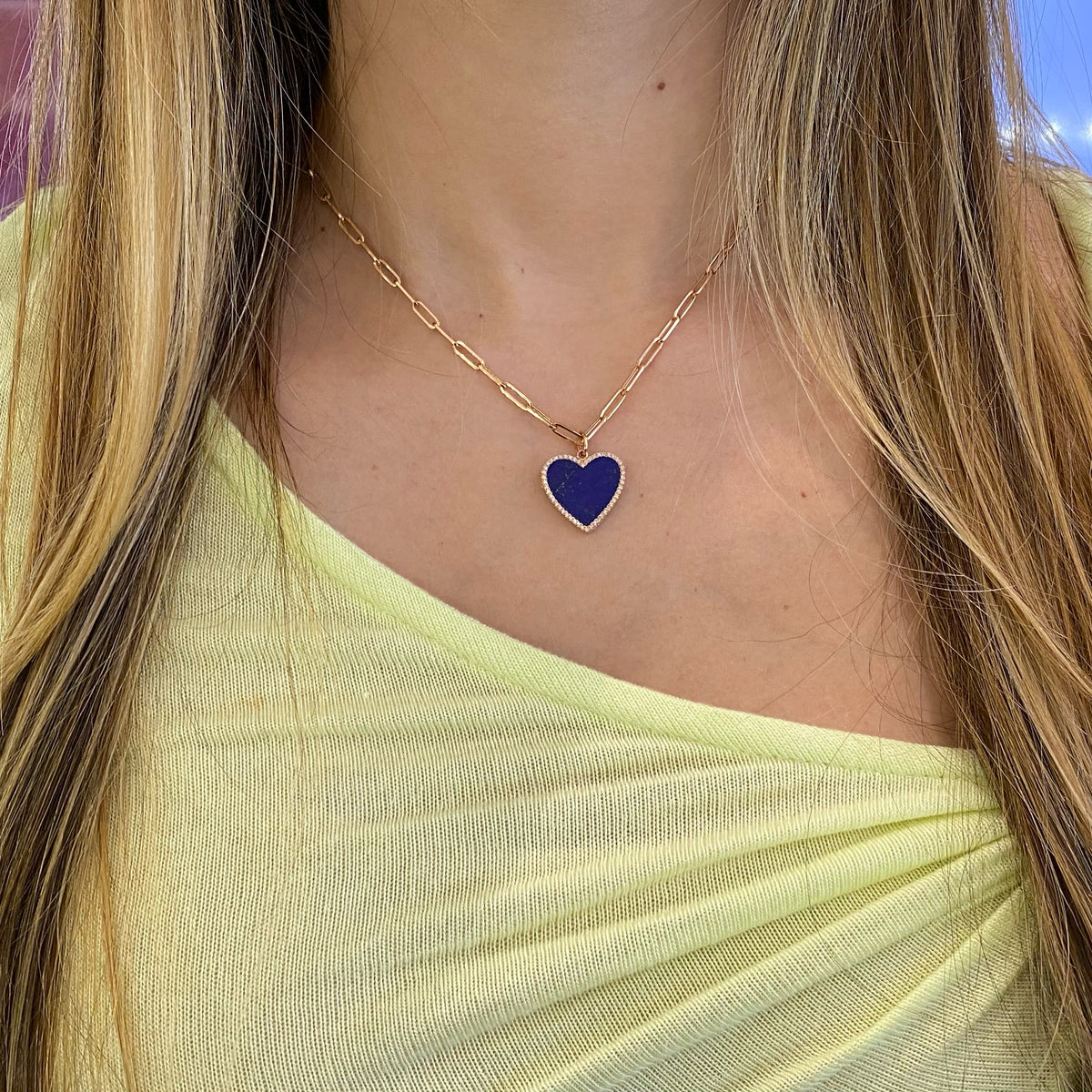 Female model wearing Lapis & Diamond Heart Locket - 14K gold weighing 3.89 grams - 50 round diamonds totaling 0.16 carats - 3.71 ct lapis