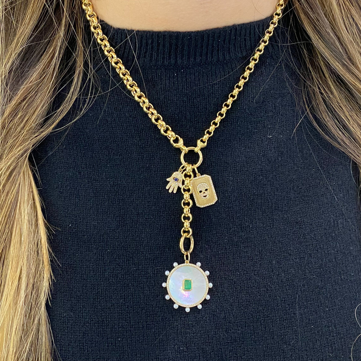 Female model wearing Emerald & Mother of Pearl Charm - 14K yellow gold weighing 2.99 grams - 0.49 ct emerald - 74 round diamonds totaling 0.15 carats