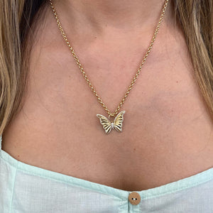 Female model wearing Diamond Butterfly Pendant - 14K yellow gold weighing 3.81 grams - 102 round diamonds totaling 0.31 carats