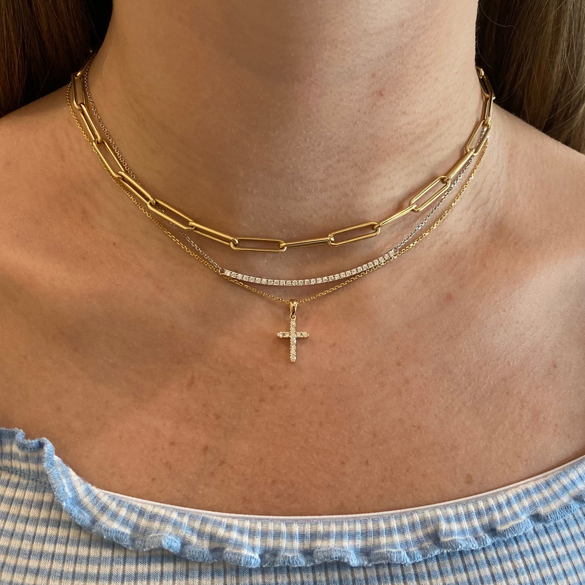 Female Wearing Model Diamond 11-Stone Cross Pendant  - 14K gold weighing 2.36 grams  - 11 round diamonds totaling 0.20 carats